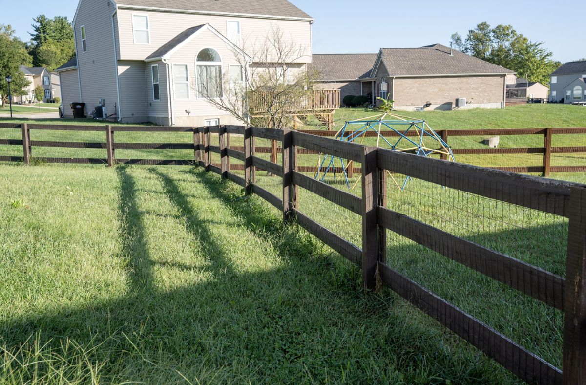 Kentucky Board Fence Installation in Middletown, Ohio 4 Existing Kentucky Board fence with a weathered finish, providing a classic rural-style boundary for a residential property.