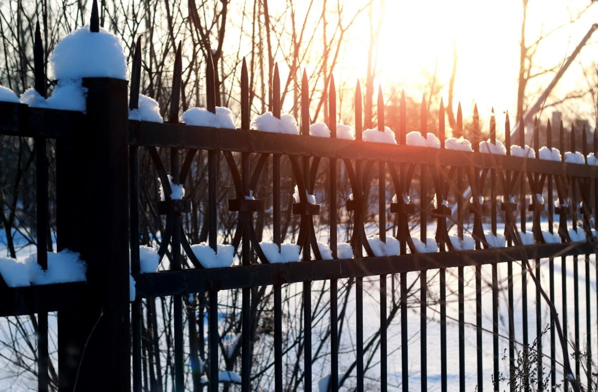 Low-maintenance vinyl and aluminum fencing beside a stained wood fence, showing different upkeep needs for Southwest Ohio homes.